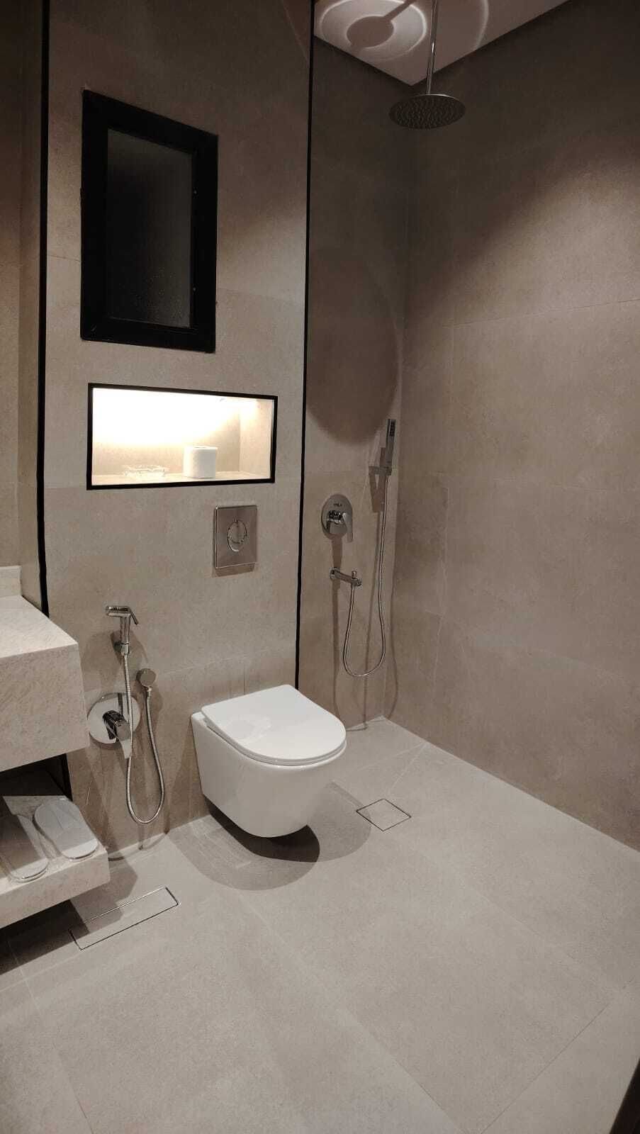 A modern bathroom with a toilet, bidet, and shower.