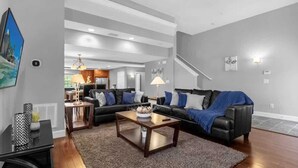 Ein modernes Wohnzimmer mit einer Eckcouch, einem Couchtisch und einem Fernseher.