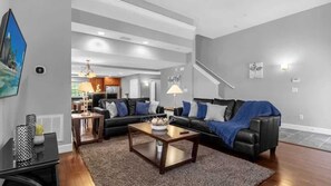 Ein modernes Wohnzimmer mit einer Eckcouch, einem Couchtisch und einem Fernseher.