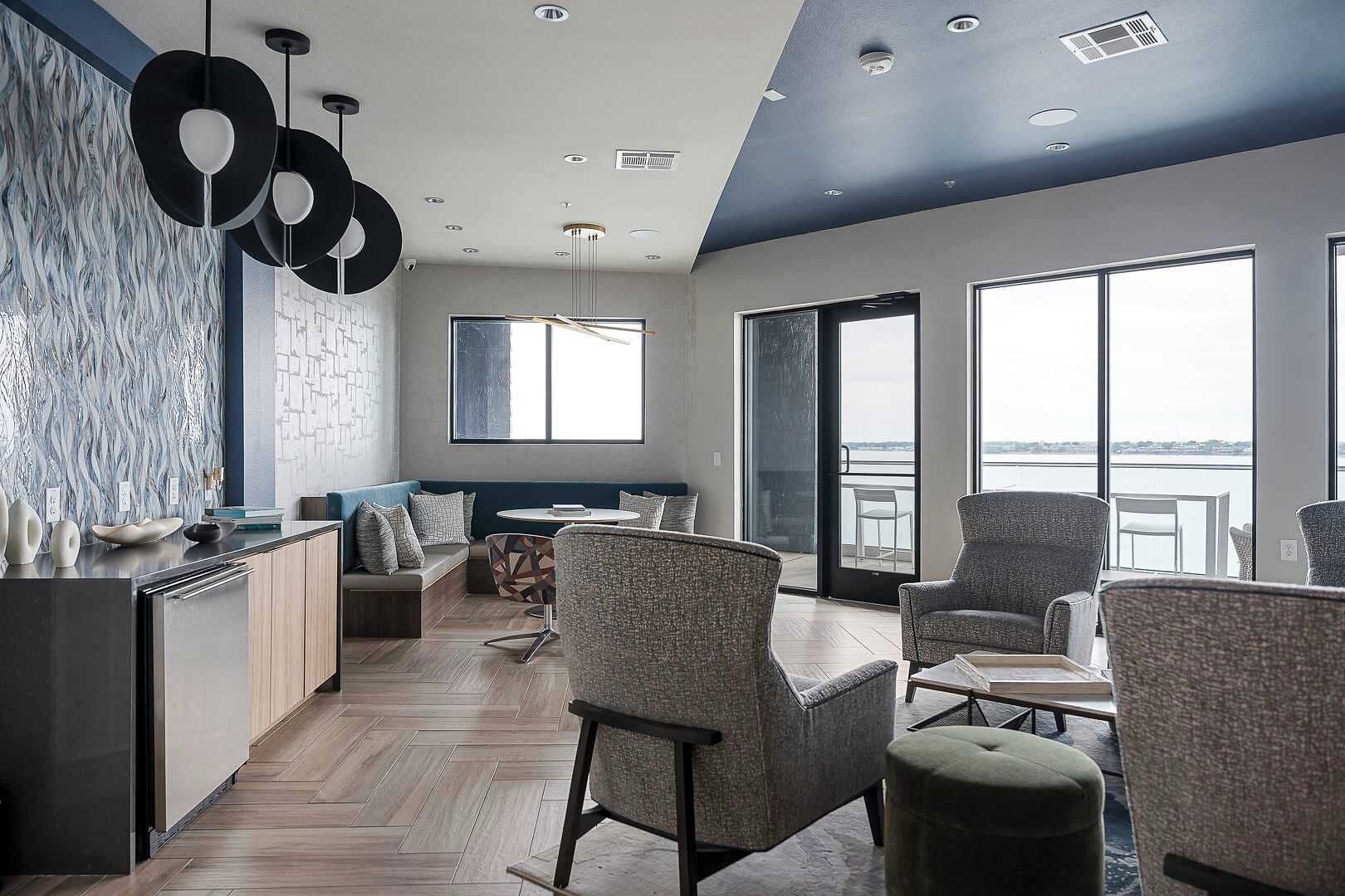 A modern interior with a kitchen, seating area, and large windows offering views.