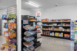 Ein Supermarkthecken mit Regalen voller Snacks, Getränke und Haushaltswaren.