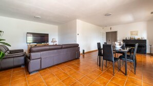 A living room with a sofa and a television, a dining area with chairs and a table, and a kitchen with a stove and cabinets. - La Villa Peace & Goodness (Vidauban)
