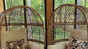Two wicker chairs with cushions and a small table with decorative items in between.