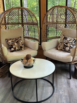 Two wicker chairs with cushions and a small table with decorative items in between. - Newly Remodeled Modern house with AC in Crosslake w/ Firepit and Free Wood (Crosslake)