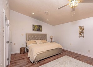 A bedroom with a bed, bedside table, lamp, and a ceiling fan. - Havasu Acoma - Pool, Spa, Game Room, Sleeps 16 (Lake Havasu City)