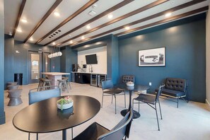 A modern interior with a kitchen, dining area, and seating. - DallasHaus | Pool & Gym, Love Field (Dallas)