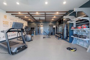 A gym with treadmills, weight machines, and a punching bag. - DallasHaus | Pool & Gym, Love Field (Dallas)