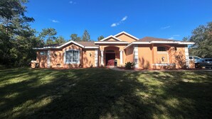 A single-story house with a front porch, a garage, and a well-maintained lawn.