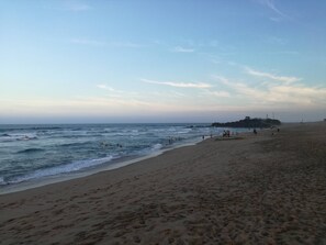 A beach with a clear sky, waves, and people. - Cabanas on the Beach Warner Beach (Kingsburgh)