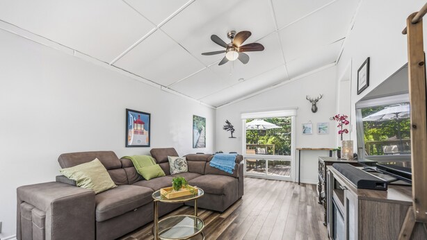 A modern living room with a sofa, coffee table, and a ceiling fan. - The Little Lighthouse (Sarnia)