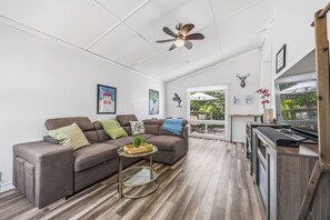 A modern living room with a sofa, coffee table, and a ceiling fan. - The Little Lighthouse (Sarnia)