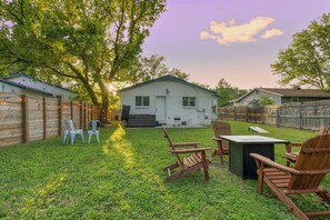 A backyard with a wooden deck, outdoor seating, and a house. - East Austin Retreat w/ Hot Tub & Backyard (Austin)