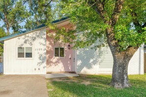 A single-story house with a pink door and a mailbox. - East Austin Retreat w/ Hot Tub & Backyard (Austin)