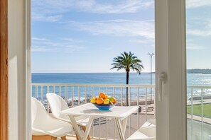 A balcony with a table, chairs, and a bowl of fruit. - Skyline Cala Nau by Rentallorca (Cala Millor)