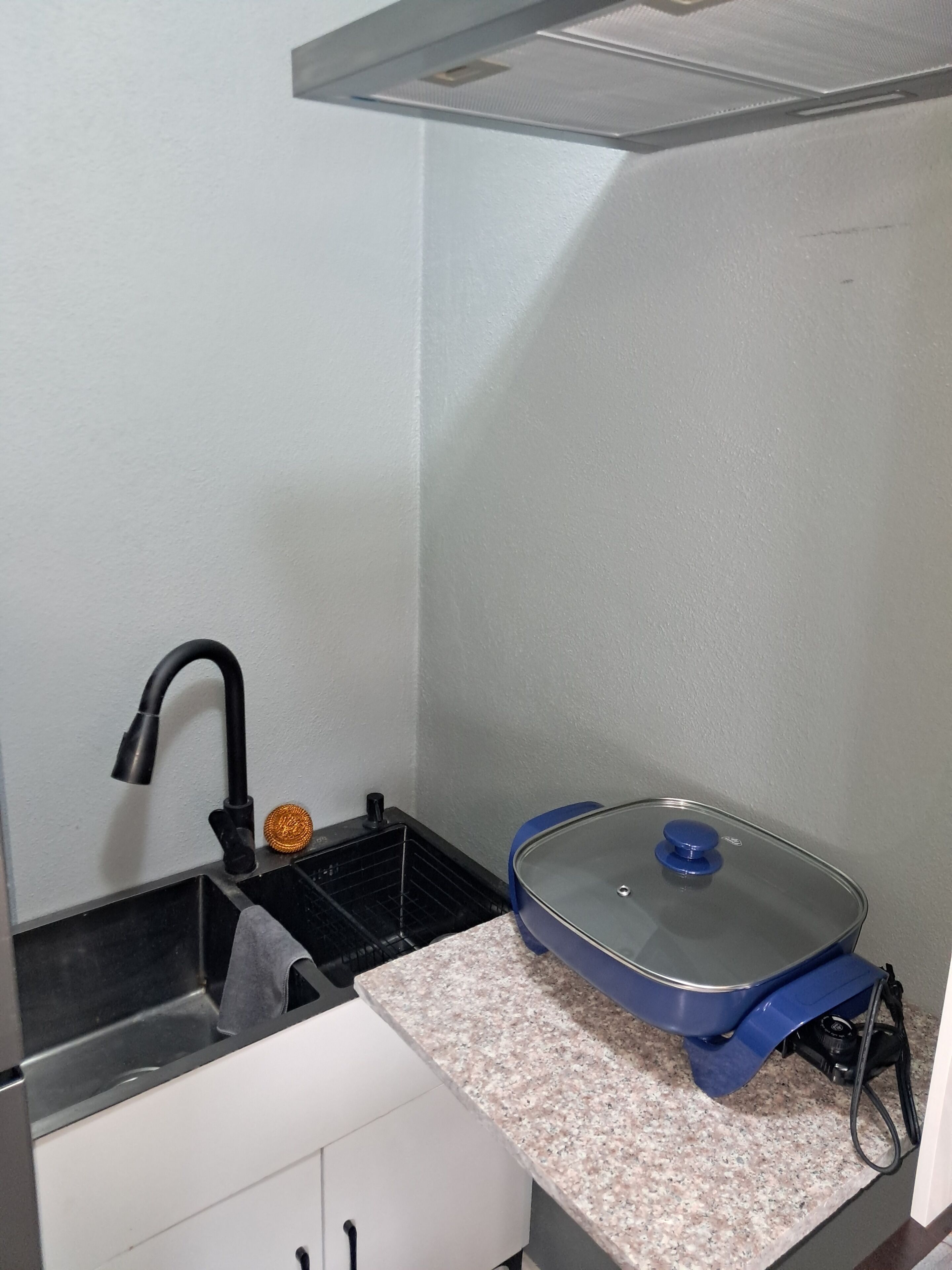 A compact kitchen with a sink, a stove, and a countertop.