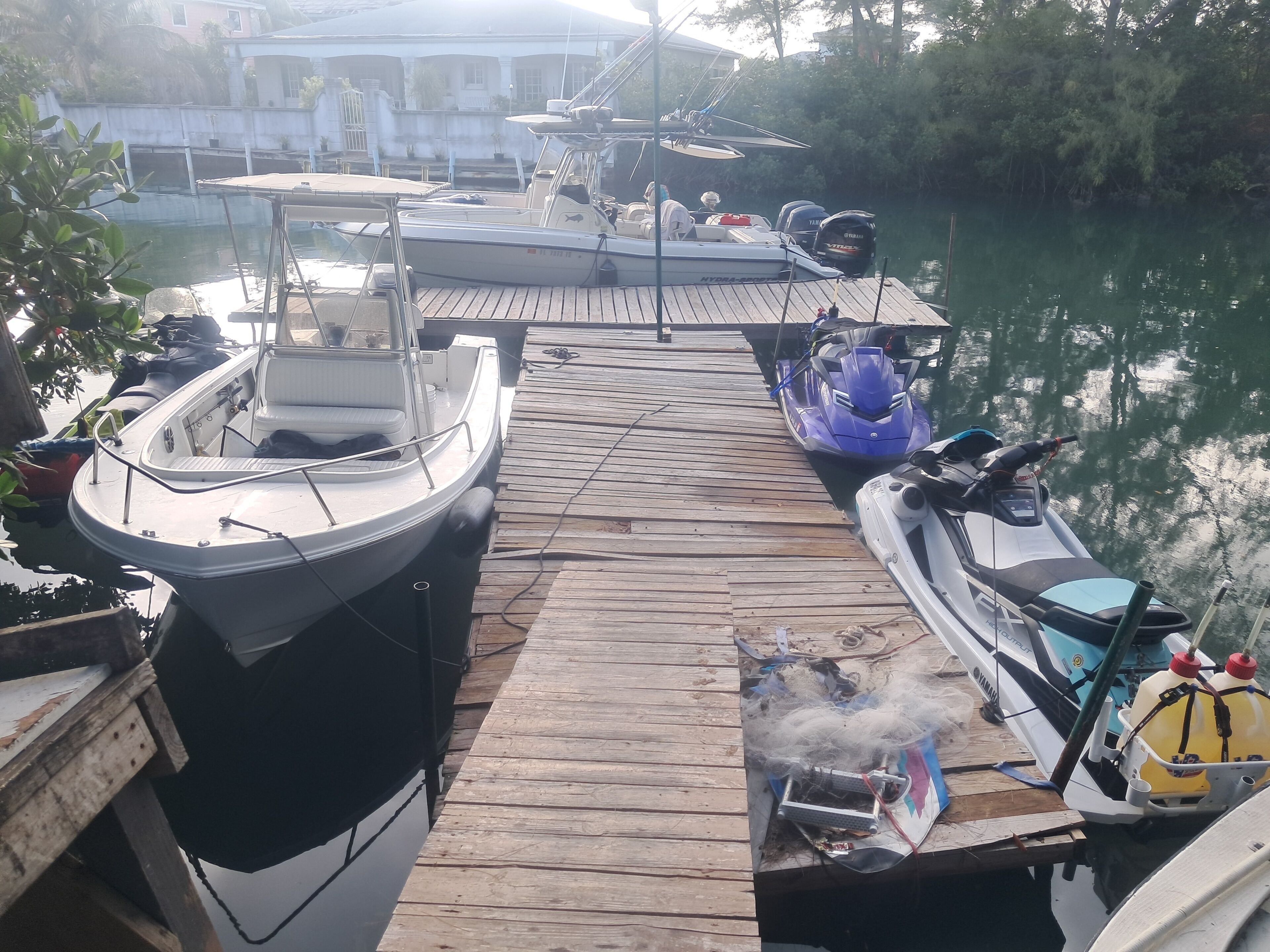 A dock with boats, a jet ski, and a motorized watercraft.