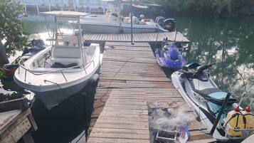 A dock with boats, a jet ski, and a motorized watercraft.