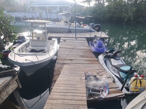 Ein Steg mit Booten, einem Jetski und einem Motorboot.