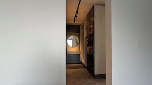 A hallway with a wooden floor, a round mirror, and a modern light fixture. - Spectacular country house, in the coffee region, 5 minutes from the coffee park. (Armenia)