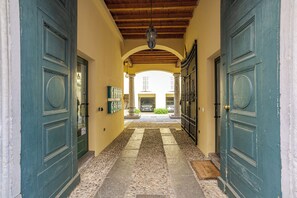 Ein Korridor mit zwei großen Türen, Fliesenboden und einer gewölbten Decke.