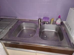 A kitchen with two stainless steel sinks, a dish rack, and a soap dispenser. - Studio cabin+parking near beach (Agde)