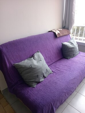 A purple sofa with two grey pillows and a brown throw blanket. - Studio cabin+parking near beach (Agde)