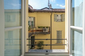 A yellow building with a balcony, a window, and a small plant. - Como Center Studio, Como, Italy (Como)
