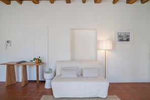 Ein Schlafzimmer mit einem Bett, Nachttisch, Lampe und einem gerahmten Bild an der Wand.
