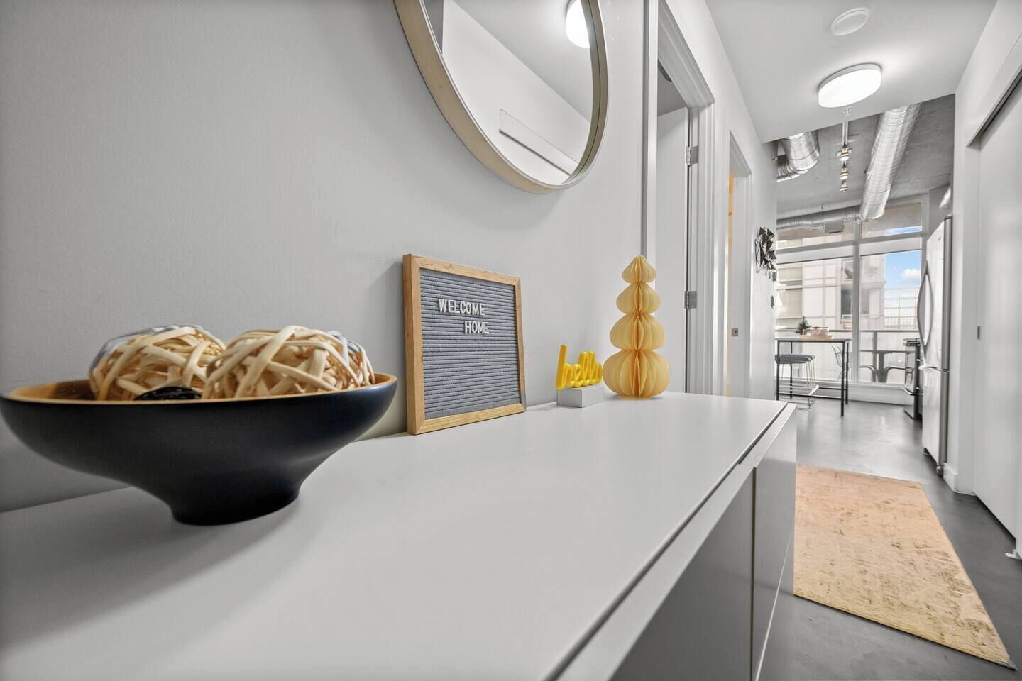 Una cocina moderna con un plato de pasta, un cartel de bienvenida y un jarrón decorativo.