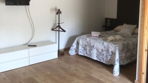 Un dormitorio con cama, mesita de noche y lámpara colgante.
