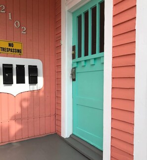 Ein Haus mit einer türkisblauen Tür, einem 'NO TRESPASSING'-Schild und einem Briefkasten.