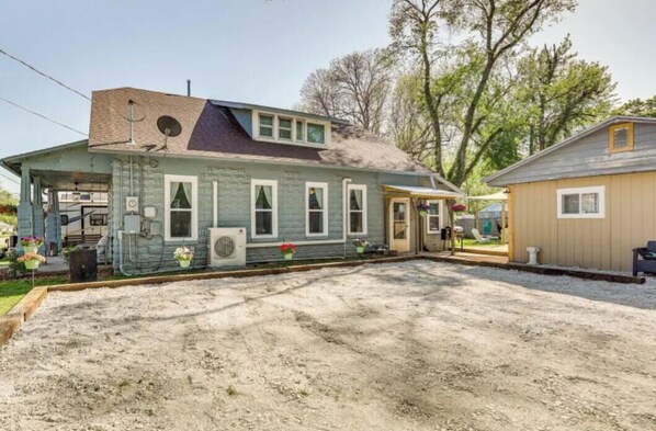 Ein zweigeschossiges Haus mit Veranda, Garage und einem kleinen Anbau.