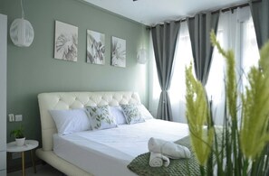 Un dormitorio con cama, una mesita de noche, una planta en maceta y una obra de arte en la pared.