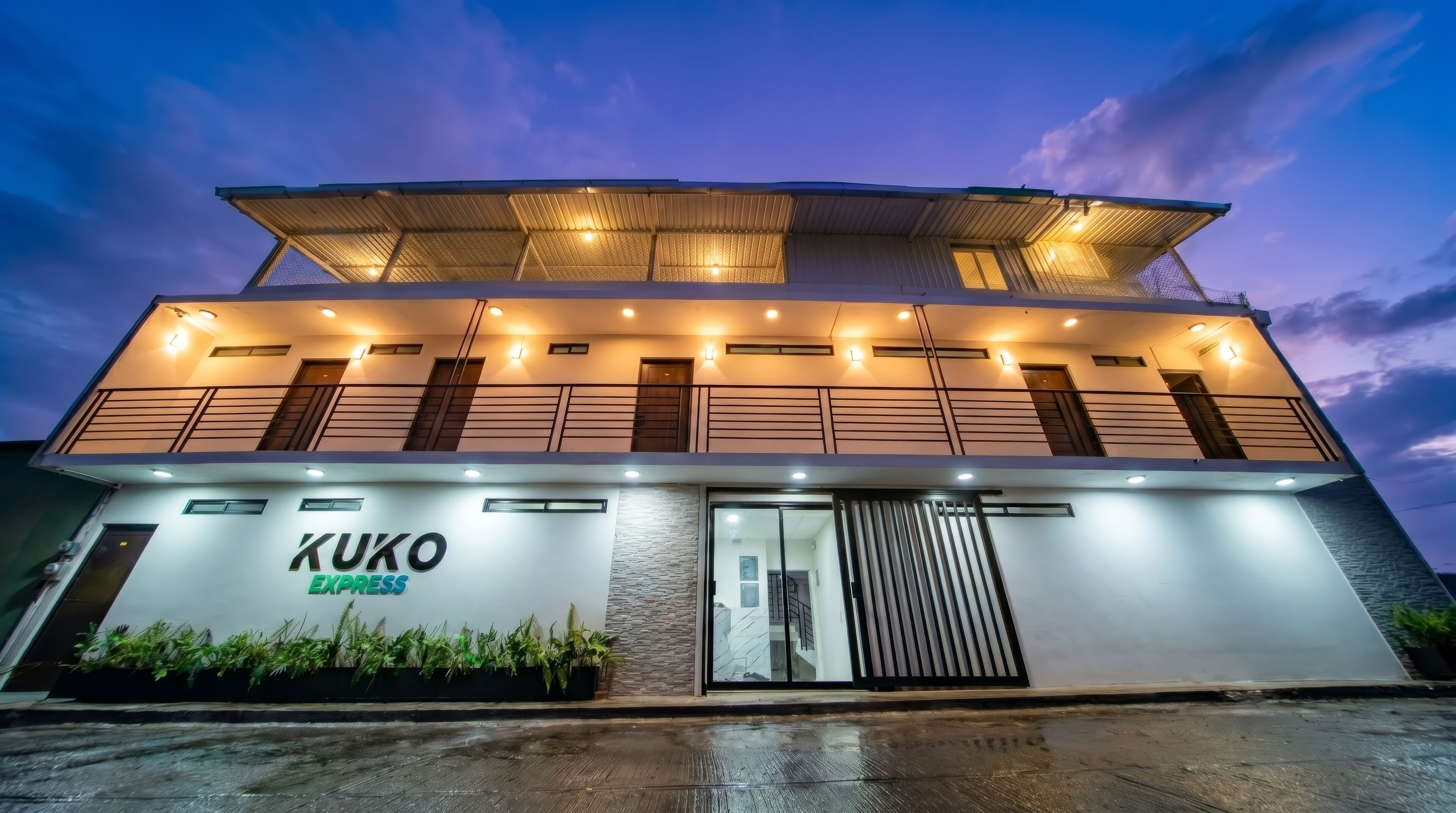 Un edificio moderno con un letrero que dice 'KUKO EXPRESS' y una entrada de vidrio.