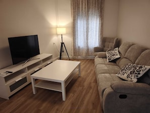 A living room with a TV, white coffee table, sofa, and a lamp. - Casa Juanito Rute, in the heart of the Sierras Subbeticas, discover Andalusia. (Rute)
