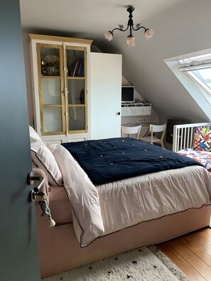 Un dormitorio con cama, armario, escritorio y televisor.