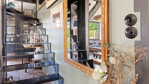 A modern interior with a staircase, a large mirror, and a vase with dried plants. - Guest Room "Escale Sauzonnaise - La Baie" with Sea View, Shared Pool and Wi-Fi (Sauzon)