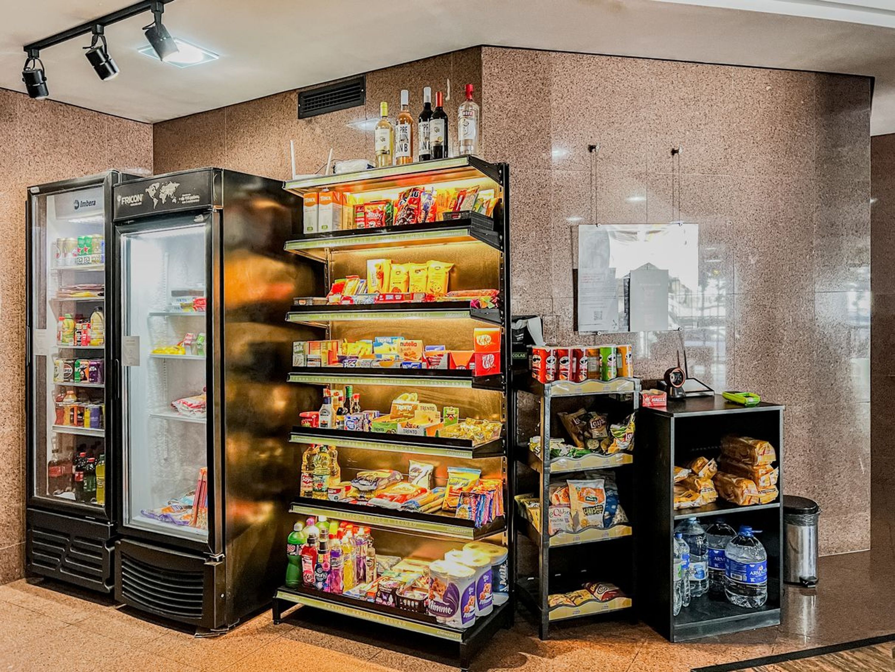 Eine Selbstbedienungsstation für Getränke und Snacks mit gekühlten und ungekühlten Optionen im Hotel-Lobby.