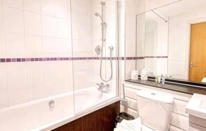 Ein Badezimmer mit Dusche, Toilette und Waschbecken.