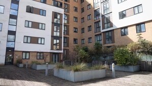 Un edificio residencial de varios pisos con un patio.