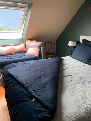 Quarto com duas camas, janela, cadeira e abajur.