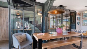 Un interno moderno con un tavolo da pranzo in legno, una panca e una sedia grigia con cuscino decorato.