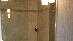 A bathroom with a large mirror, a sink, and a shower area. - Cozy Deluxe Queen Room in Minneapolis Boutique Hotel (Minneapolis)