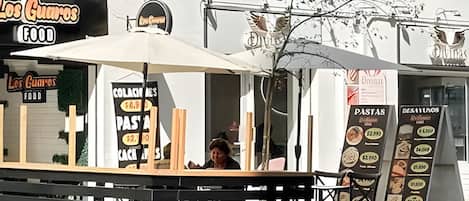 Un stand de restauration en plein air avec un panneau affichant le menu et une enseigne indiquant « Los Cuartos Food ».