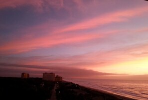 Eine Küstenlandschaft mit Gebäuden am Ufer, einem klaren Himmel und einem Sonnenuntergang.