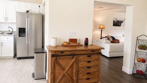 Una cucina con frigorifero, lavastoviglie e un mobile contenitore in legno.