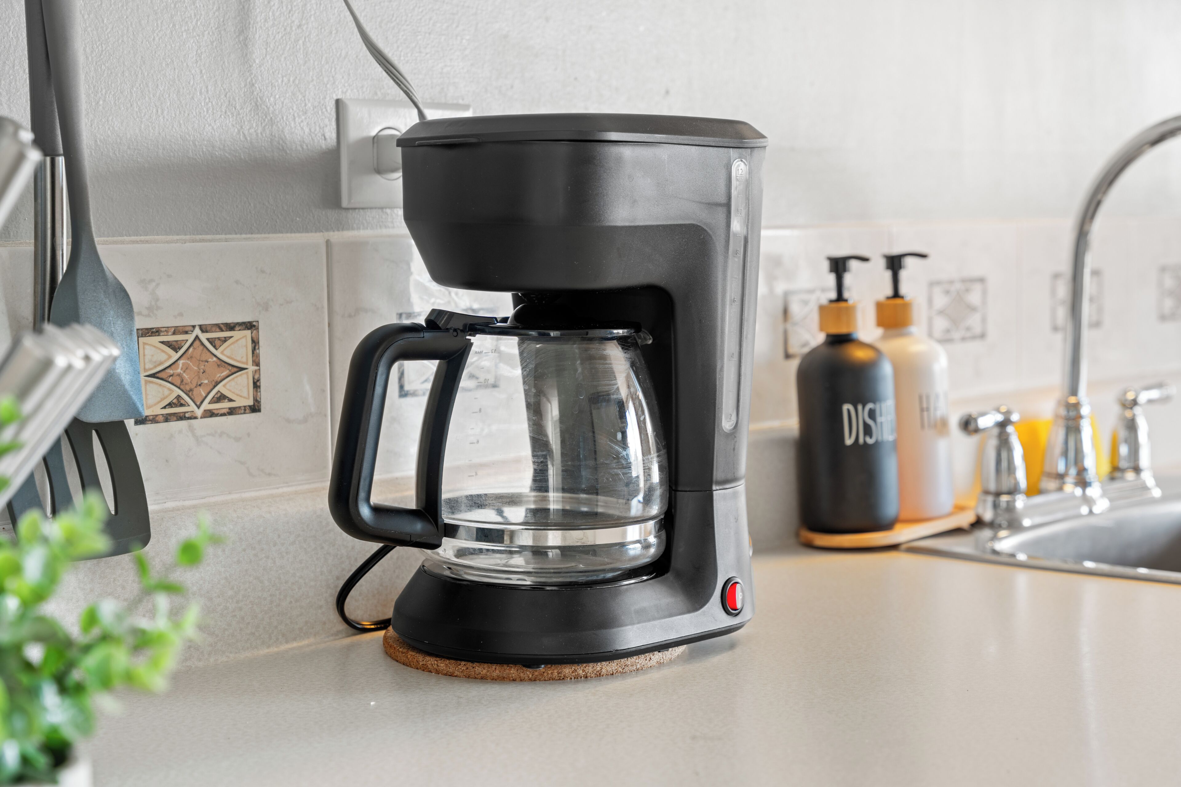 Une cuisine équipée d’une machine à café, d’un évier et de produits de toilette.