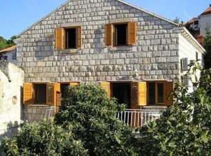 A stone building with wooden shutters, a balcony, and a white railing. - Old Town Bay Cavtat Sea View (Konavle)