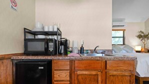 Une cuisine compacte équipée d’un four à micro-ondes, d’une machine à café et d’un évier.