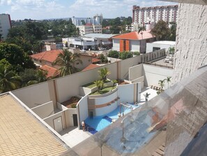 Un edificio residencial con piscina, varios balcones y vistas de edificios circundantes.
